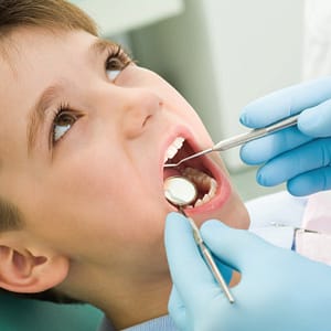 young boy receiving dental fissure sealants in the dentists chair image