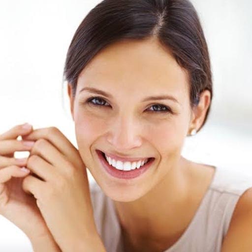 Woman smiling about the cost of dentistry image